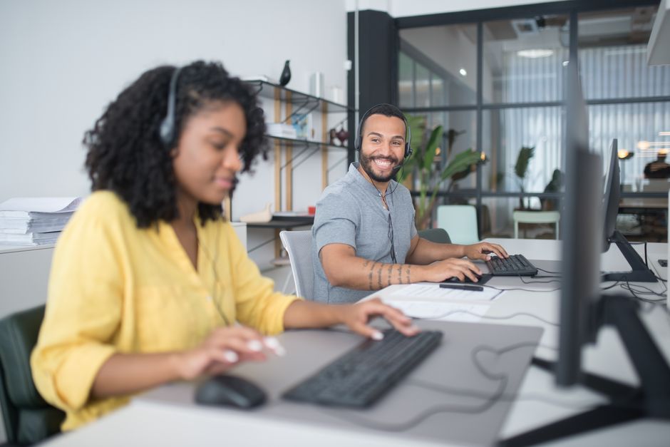 Uma equipe diversificada de call center trabalhando eficientemente com headsets e computadores, garantindo um atendimento ao cliente de qualidade.