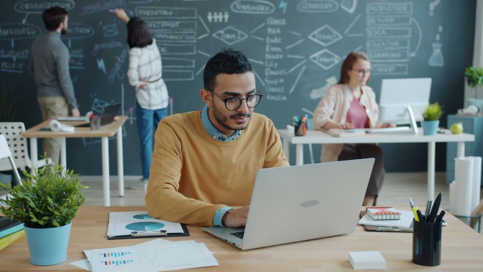 Jovens profissionais colaborando em um ambiente de trabalho moderno e criativo.