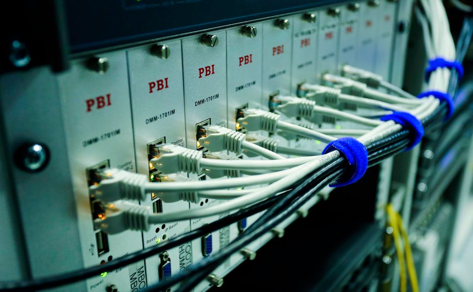 Close-up de cabos Ethernet conectados a um painel de switch de rede em um data center.