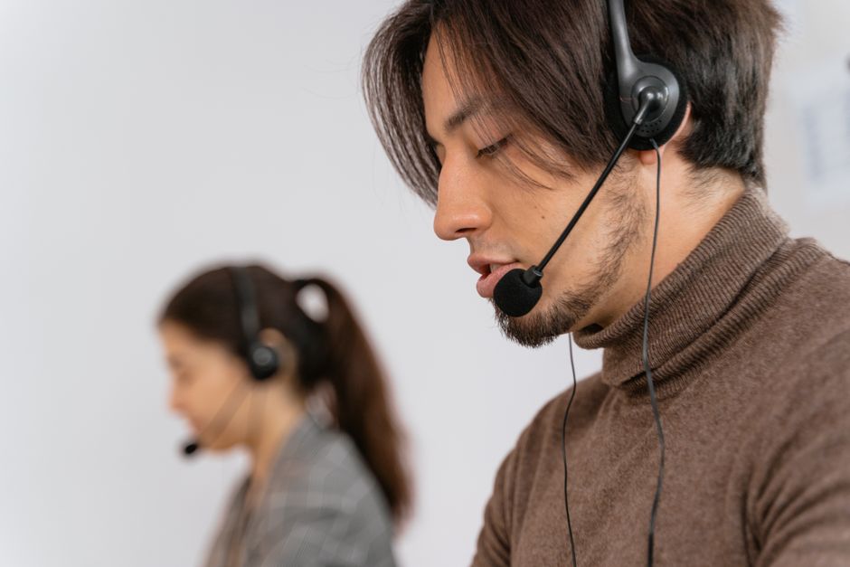 Funcionários de call center focados usando fones de ouvido, ajudando clientes com um serviço excepcional.